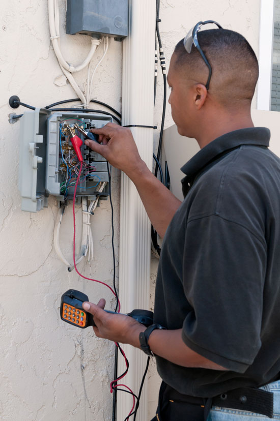 photo of technician testing electrical circuits in a home